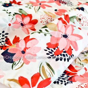 May include: White cotton fabric with a pink and red floral print. The flowers are stylized and have a watercolor effect. The background is white with a subtle texture.