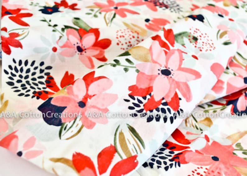 May include: White cotton fabric with a pink and red floral print. The flowers are stylized and have a watercolor effect. The background is white with a subtle texture.
