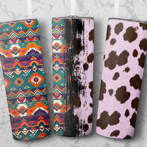 May include: Three stainless steel insulated tumblers with different designs. One has a teal, orange, and purple geometric pattern. The second has a black distressed paint design. The third has a pink cowhide pattern.