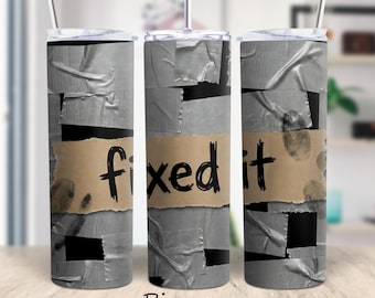 Könnte beinhalten: Ein Edelstahlbecher mit Deckel und Strohhalm. Der Becher ist mit einem Design verziert, das Klebeband nachahmt, und einem braunen Papieretikett mit der Aufschrift "fixed it" in schwarzer Schrift. Fingerabdrücke sind ebenfalls sichtbar.