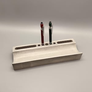 Może przedstawiać: Zestaw trzech ceramicznych kubków z nakrapianym, matowym wykończeniem. Kubki są w odcieniach kremu, jasnego brązu i ciemnego brązu. Każdy kubek ma prosty, minimalistyczny design.