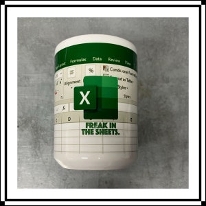 May include: White ceramic mug with a green and white design of a spreadsheet with the text "FREAK IN THE SHEETS."