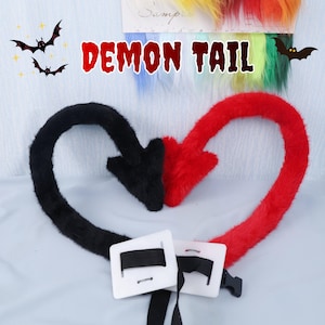 May include: A plush, two-toned demon tail in black and red, shaped like an arrow. The tail features a white buckle with a black strap for attachment. The words "DEMON TAIL" are written in red, with bat illustrations.