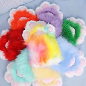 May include: A collection of colorful, plush paw pads in various shades including red, orange, yellow, green, blue, purple, and rainbow. Each paw pad features a white border and pink paw pads, creating a playful and vibrant aesthetic.