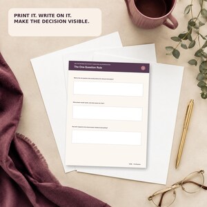 May include: A printed worksheet titled The One-Question Rule with a dark purple header and three blank rectangular fields for writing. The text PRINT IT. WRITE ON IT. MAKE THE DECISION VISIBLE. is displayed in a separate beige box above.