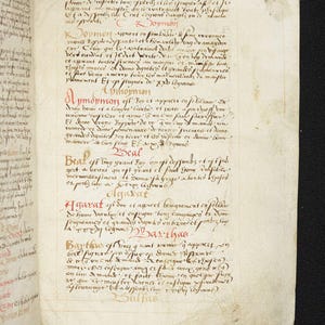 May include: Open book with handwritten text in red and black ink. The aged pages display script in a medieval style, with annotations and headings. The text appears to be a religious or historical document.
