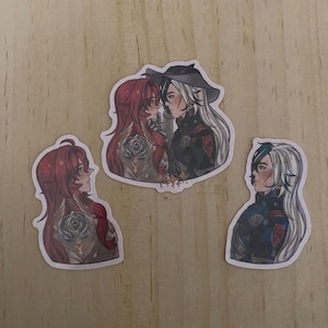 May include: Three stickers with anime-style illustrations. One shows two characters facing each other, the other two show individual characters. The characters have red and white hair, and are wearing detailed outfits.