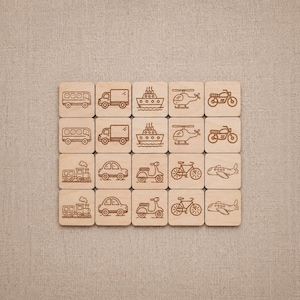 May include: Wooden transportation-themed tiles with engraved illustrations of various vehicles, including buses, trucks, ships, helicopters, motorcycles, trains, cars, scooters, bicycles, and airplanes. The tiles are arranged on a neutral-colored fabric surface.