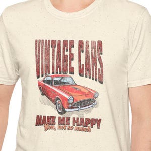May include: Cream-coloured t-shirt with a distressed graphic of a red vintage car. The text "VINTAGE CARS" is above the car, and below it, "MAKE ME HAPPY You, not so much" is printed in a matching distressed style.