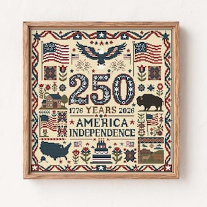 May include: Framed cross-stitch celebrating 250 years of American Independence. The design features the American flag, an eagle, a bison, and the text "America Independence" with the years 1776 and 2026. The color palette includes red, white, blue, and brown.