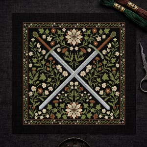 May include: Cross-stitch design featuring two crossed swords over a floral pattern. The design includes green, brown, and cream-colored flowers and foliage on a black background. The swords have silver blades and brown handles.