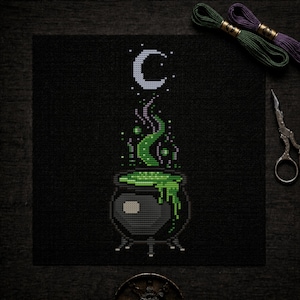May include: A cross-stitch pattern on black fabric featuring a gray cauldron with bubbling bright green liquid, wisps of green smoke rising upward, and a white crescent moon above. The design is rendered in a pixelated style with visible stitches.