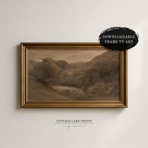 May include: A sepia-toned landscape painting in a gold frame. The artwork depicts a serene valley scene with trees and rolling hills. The text "DOWNLOADABLE FRAME TV ART" is in a black oval. The text "COTTAGE LANE PRINTS vintage inspired art" is below the frame.