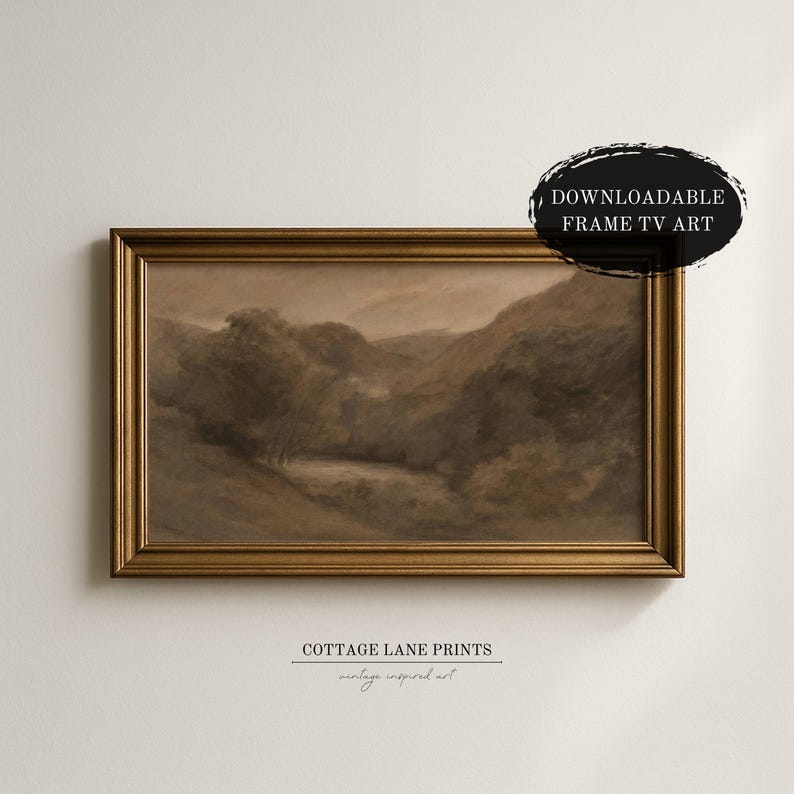 May include: A sepia-toned landscape painting in a gold frame. The artwork depicts a serene valley scene with trees and rolling hills. The text "DOWNLOADABLE FRAME TV ART" is in a black oval. The text "COTTAGE LANE PRINTS vintage inspired art" is below the frame.