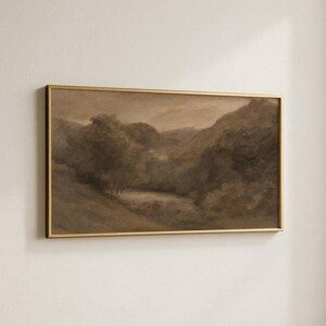 May include: A sepia-toned landscape painting in a gold frame. The artwork depicts a valley with trees, hills, and a body of water. The painting has a vintage aesthetic, with soft brushstrokes and a muted color palette.