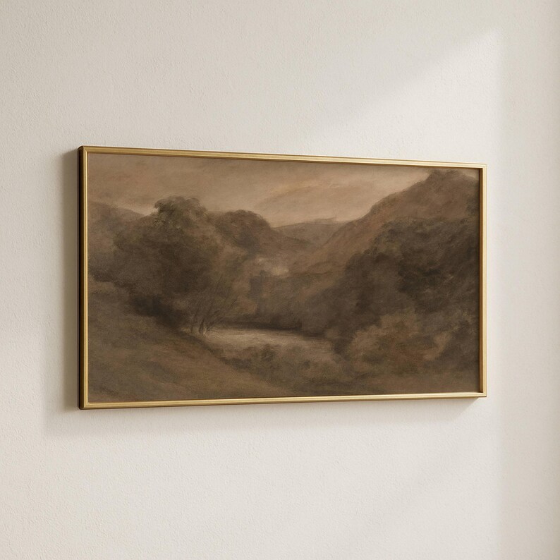 May include: A sepia-toned landscape painting in a gold frame. The artwork depicts a valley with trees, hills, and a body of water. The painting has a vintage aesthetic, with soft brushstrokes and a muted color palette.