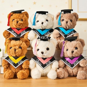 Puede incluir: Seis osos de peluche con gorros y estolas de graduación. Cada oso tiene una estola de diferente color con un nombre y el año 2026 impresos. Los osos son marrones y blancos, y están colocados sobre una superficie de madera.