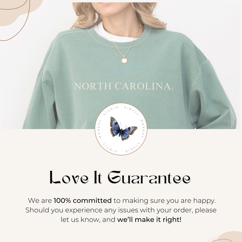 May include: A pale green sweatshirt with the words "NORTH CAROLINA." in white. A circular logo featuring a blue butterfly is below the text. The text "Love It Guarantee" is displayed in a decorative font.