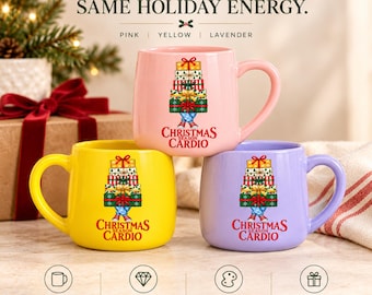 May include: Three ceramic mugs in pink, yellow, and lavender, each with a 17 oz capacity and a glossy finish. The front of each mug features a graphic of stacked Christmas presents with legs and the red text CHRISTMAS SEASON CARDIO.