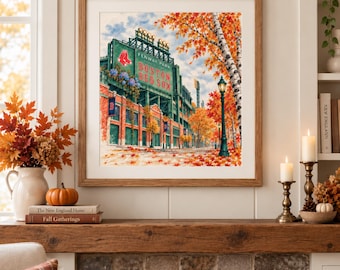 May include: A framed print depicting Fenway Park in Boston with the text Fenway Park Boston Red Sox. The scene features the stadium exterior surrounded by autumn trees with orange and red leaves, a street lamp, and fallen leaves on the ground.