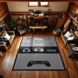 Peut inclure: Tapis de jeu gris et noir avec des icônes de manettes de jeu, des écouteurs et un motif de clavier. Le tapis présente un grand graphisme de manette de jeu en bas. Le tapis est dans une pièce avec des planchers et des meubles en bois.