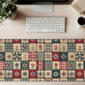 May include: A rectangular desk mat with a patchwork design featuring floral and geometric patterns in red, blue, and beige. The mat is designed to protect the desk surface and provide a smooth surface for a mouse and keyboard.