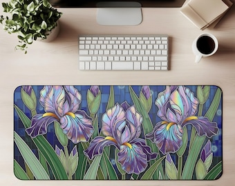 May include: A rectangular desk mat with a stained-glass effect, depicting purple irises with yellow centres and green leaves on a blue backdrop. The mat is designed to protect the desk surface and provide a smooth surface for a mouse and keyboard.