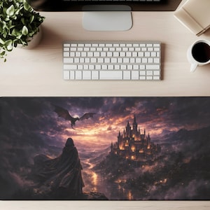 May include: A black rectangular desk mat featuring a fantasy landscape. A cloaked figure stands before a castle, with a dragon flying in the sky. The scene is set against a sunset with shades of orange, purple, and black.
