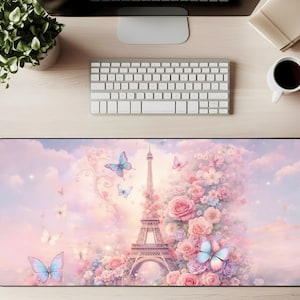 May include: A rectangular desk mat featuring a pastel illustration of the Eiffel Tower, butterflies, and flowers. The design incorporates shades of pink, blue, and white, creating a dreamy aesthetic. The mat is designed to protect the desk surface.