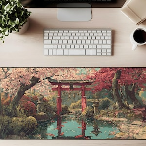 Op de afbeelding: Een rechthoekige muismat met een serene Japanse tuinscène. Het ontwerp omvat een rode torii-poort, kersenbloesem bomen, een vijver met koi-vissen en stenen lantaarns. Het kleurenpalet wordt gedomineerd door roze, rood en groen.
