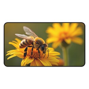 May include: A close-up of a honeybee on a yellow flower, with another flower blurred in the background. The bee has brown and black stripes and is covered in fine hairs. The flower has many yellow petals.