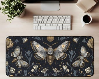 Op de afbeelding: Een rechthoekige bureaumat met een donkerblauwe achtergrond, met een gedetailleerde illustratie van motten, bloemen en bladeren in goud, grijs en wit. De mat is ontworpen om het bureaublad te beschermen en een glad oppervlak te bieden voor een muis en toetsenbord.