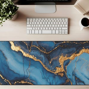 May include: A rectangular desk mat with a blue and gold marble design. The mat features a dark blue base with flowing gold veins and accents. The desk mat is designed to protect the desk surface and provide a smooth surface for a mouse and keyboard.
