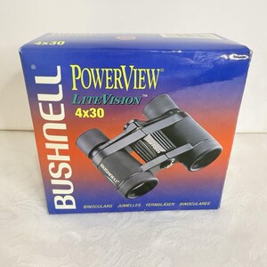 May include: A pair of black Bushnell PowerView LiteVision 4x30 binoculars, with the Insta Focus feature, are displayed on top of their original box. The box is blue and orange with the Bushnell and PowerView logos.