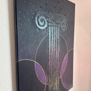 May include: Abstract canvas art showing a textured, silver column with a detailed capital. The artwork is set against a dark background with gold accents and purple circular shapes. The canvas is stretched and ready to hang.