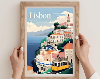 May include: A framed art print featuring a stylized illustration of Lisbon, Portugal. The artwork depicts a yellow tram, buildings, and the sea under a blue sky. The print includes the word "Lisbon" and "Tram Line 28".