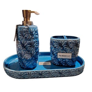 Puede incluir: Un juego de ba&ntilde;o de cer&aacute;mica azul que incluye un dispensador de jab&oacute;n con bomba dorada, un porta cepillos de dientes y una bandeja ovalada. El juego est&aacute; decorado con un patr&oacute;n floral y la marca "MORRIS & CO" es visible.