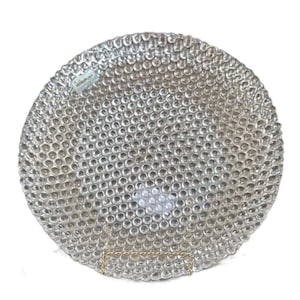 May include: A circular clear glass plate featuring a uniform raised hobnail or bubble texture across its entire surface. A small rectangular label with the text VETROPURO is visible near the upper left edge of the plate.
