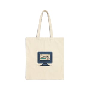 May include: A cream-coloured tote bag with a retro computer monitor graphic displaying the word "LOADING" and a progress bar. The monitor is blue with a white cursor. The bag has two long handles.