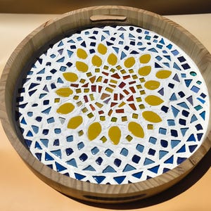 May include: Round wooden serving tray with a mosaic tile design. The center features a yellow floral pattern surrounded by blue, white, and red tiles. The tray has a natural wood finish and cut-out handles.