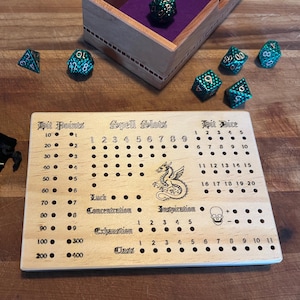 May include: A wooden game board with etched text and a dragon illustration, designed for role-playing games. Includes a black velvet bag of metal pegs, dice, and a wooden box. The board features sections for tracking hit points, spell slots, and hit dice.