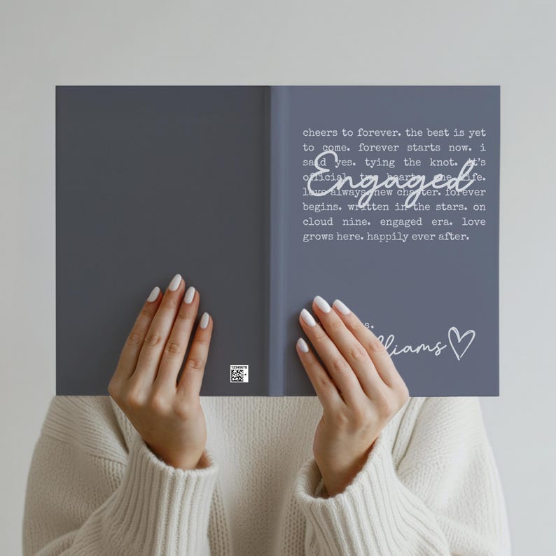 Puede incluir: Un libro gris con la palabra "Engaged" en una fuente de escritura. Las p&aacute;ginas del libro contienen texto sobre el amor y el compromiso. El libro est&aacute; sostenido por una persona con esmalte de u&ntilde;as blanco.