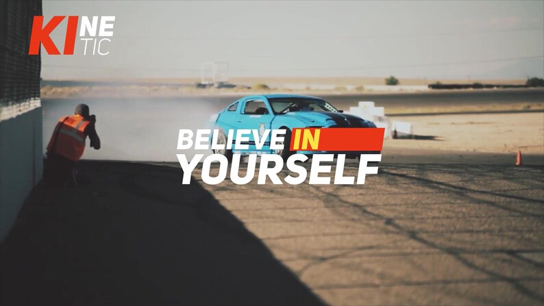 May include: A blue sports car drifts on a racetrack, with the text "BELIEVE IN YOURSELF" overlaid. A person in an orange vest is visible on the left, possibly taking photos. The word "KINETIC" is in the upper left corner.