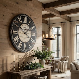 May include: Large, round wall clock with black Roman numerals and hands against a distressed, light-colored background. The clock is mounted on a wooden wall. The clock's diameter is approximately 36 inches.
