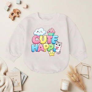 May include: White long-sleeved baby bodysuit with a colorful graphic that says "CUTE HAPPY". The design includes a winking cloud, cupcake, star, and a gray and white cat holding a heart. The bodysuit is made of a soft material.