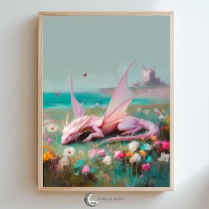 Può includere: Una stampa artistica incorniciata raffigurante un drago rosa che riposa in un campo di fiori colorati. Lo sfondo mostra un mare turchese, un castello in lontananza e un cielo azzurro. La stampa è firmata "STONE & MOON PRINTS".