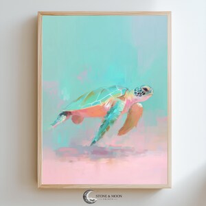 Puede incluir: Una impresión artística enmarcada que presenta una tortuga marina en tonos turquesa, naranja y rosa. La tortuga es el punto focal, sobre un fondo suave y abstracto de colores mezclados. La obra de arte está en un marco de madera.