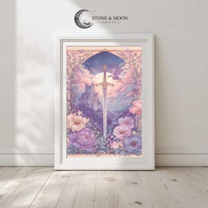 May include: A framed art print featuring a fantasy landscape with a sword, castle, and dragon. The artwork is in soft pastel colors, with a focus on purple, pink, and blue hues. The print is framed in a white wooden frame, with the text "STONE & MOON PRINTS" at the top.