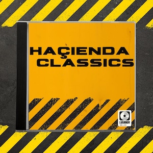 May include: A CD case with a vibrant yellow cover, displaying the text "HACIENDA CLASSICS" in large black letters. The design includes black diagonal stripes and a small logo. The case is set against a grey surface with yellow and black diagonal stripes.
