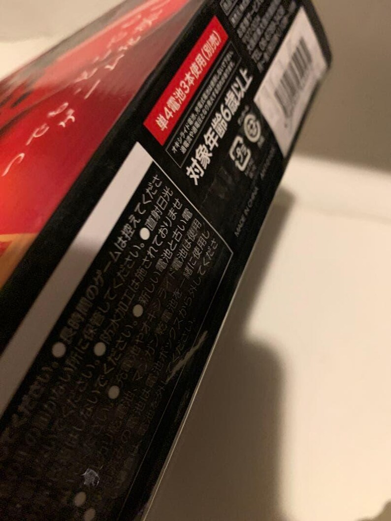 Pode incluir: Um close-up de uma caixa de produto preta e vermelha com texto japon&ecirc;s. A caixa tem uma se&ccedil;&atilde;o vermelha com texto branco e uma se&ccedil;&atilde;o branca com texto preto. O texto inclui "対象年齢6歳以上" e "MADE IN CHINA".